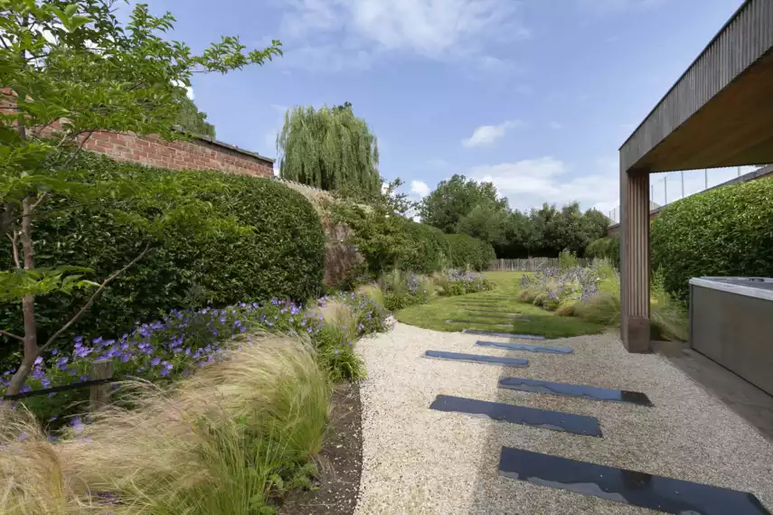 Speelse kusttuin met Dutchborder vol bloemenpracht en tuinberegening-Speelse kusttuin met Dutchborder vol bloemenpracht en tuinberegening te Oostduinkerke (1)